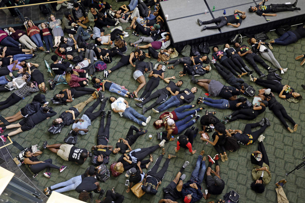 Students at the University of North Carolina Charlotte hold a vigil by lying on the floor of the student union following Tuesday's police fatal shooting of Keith Lamont Scott at The Village at College Downs apartment complex in Charlotte, N.C., Wednesday, Sept. 21, 2016. (AP Photo/Gerry Broome)           NYTCREDIT: Gerry Broome/Associated Press